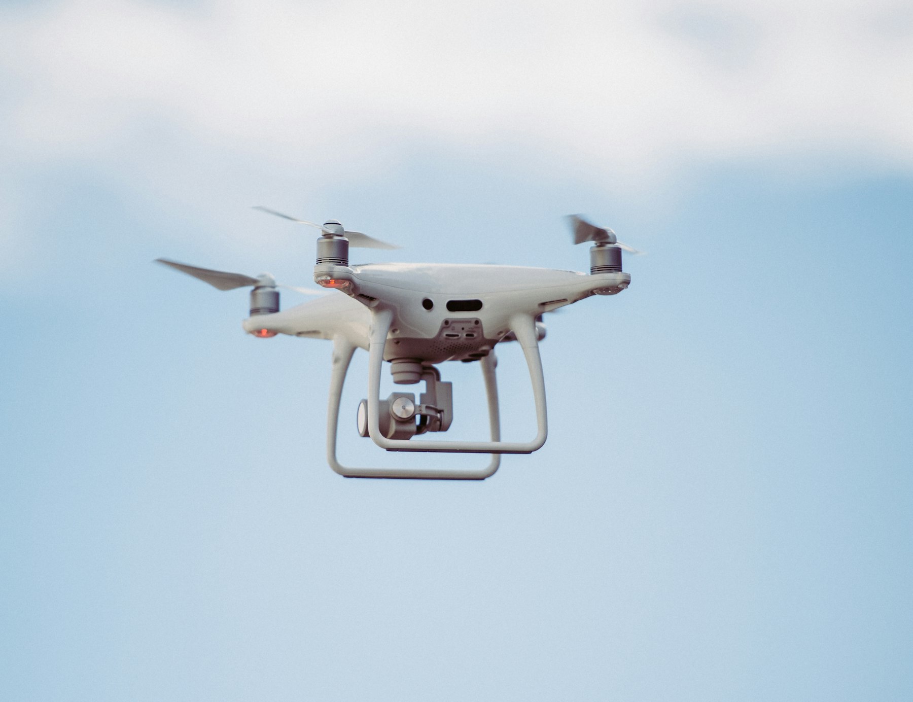 Dron DJI Phantom 4 na tle błękitnego nieba