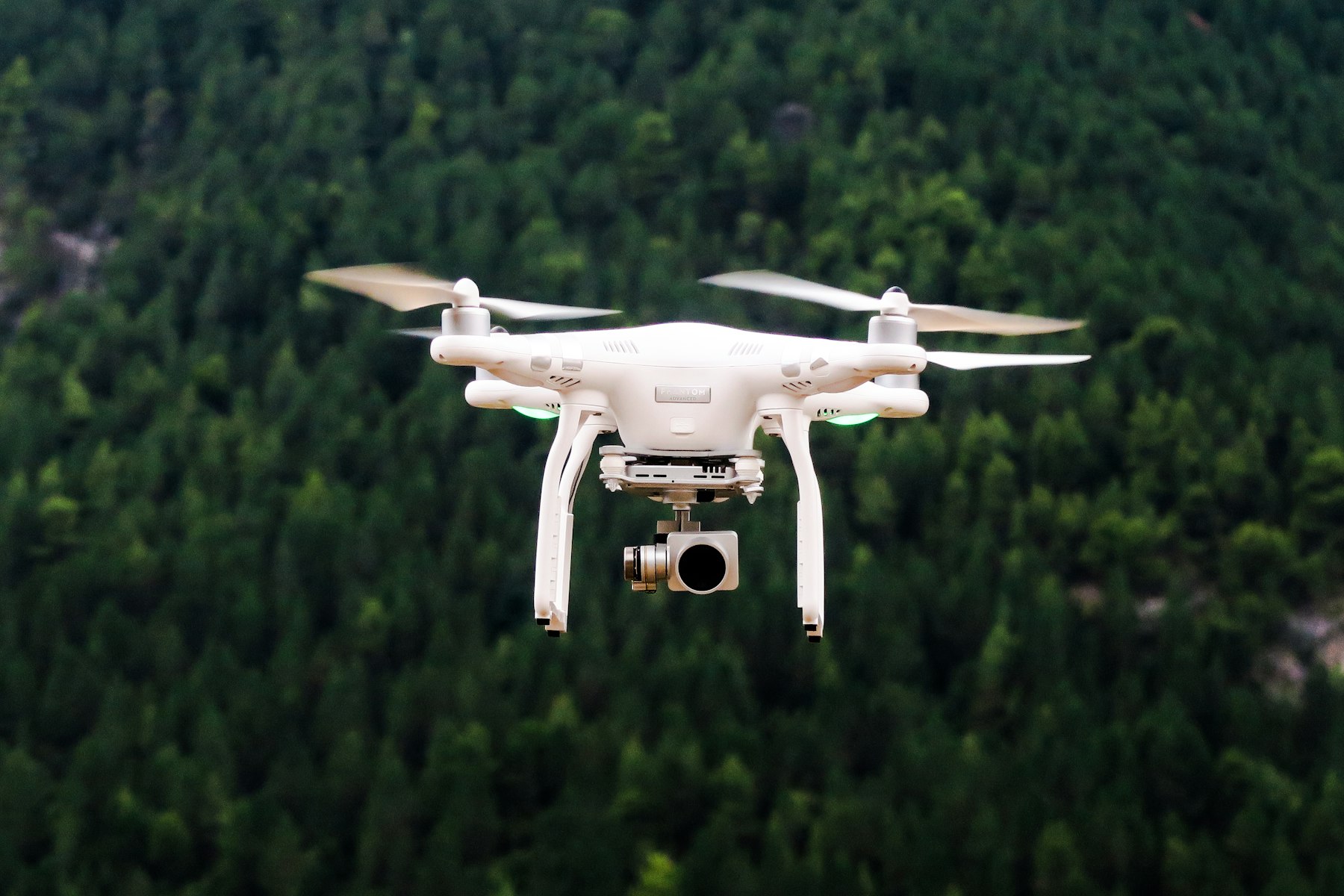 Dron z kamerą w locie nad lasem