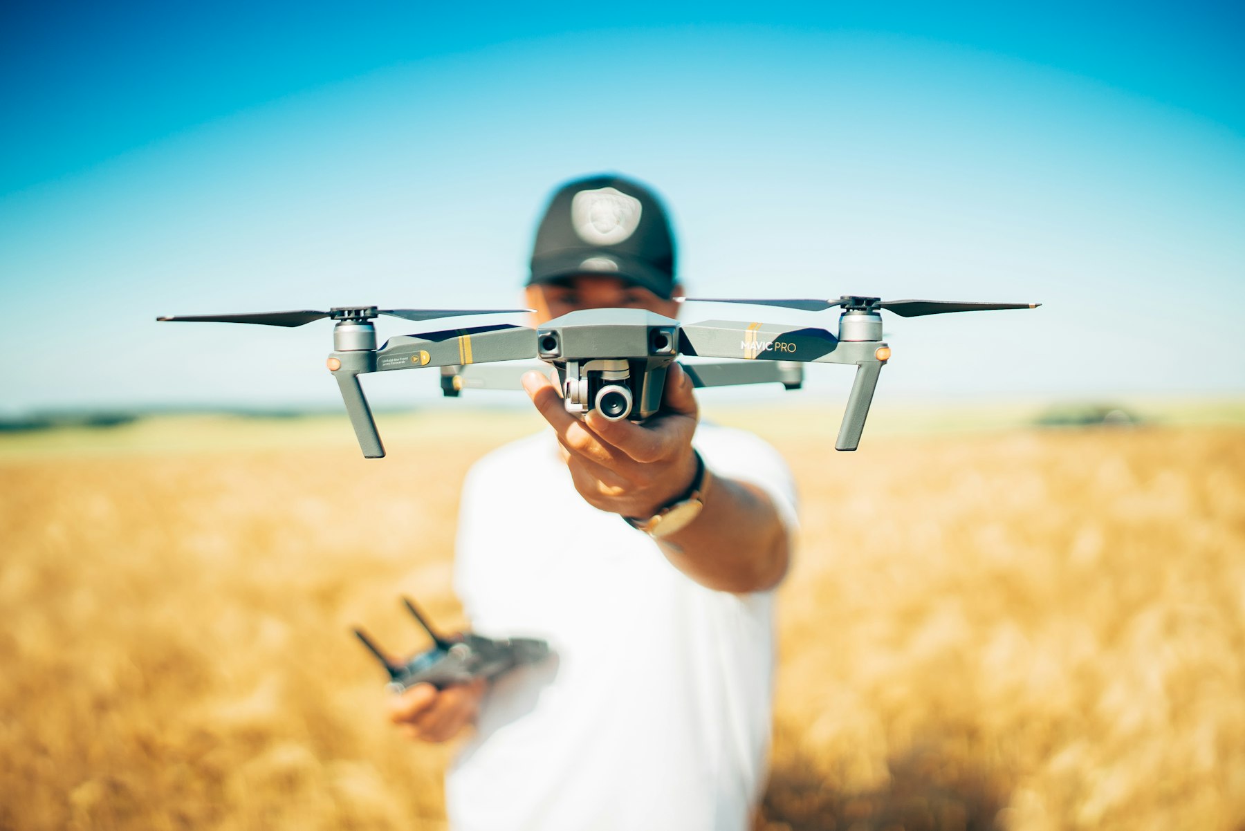 Pilot trzymający drona DJI Mavic Pro przed lotem w plenerze